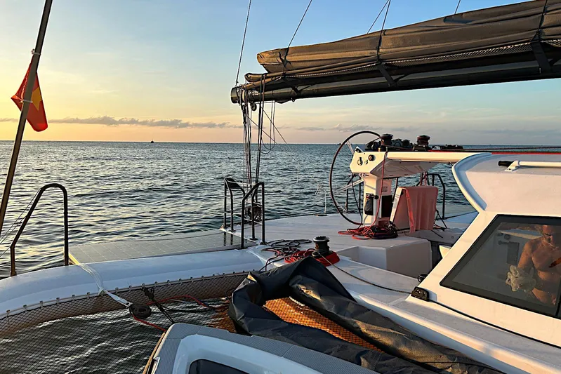  Yacht Photos Pics Sailing on a 2026 Rapido 60 trimaran at sunset, ocean view.