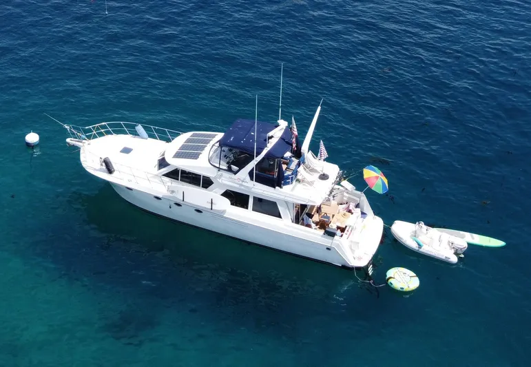 Silvius Brabo Yacht Photos Pics Navigator 53 Classic 2000 yacht anchored with inflatable toys and kayak in clear blue water.