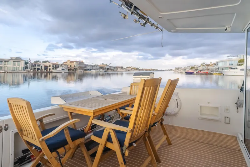 Silvius Brabo Yacht Photos Pics Deck of 2000 Navigator 53 Classic yacht with wooden chairs and table, overlooking calm waters.