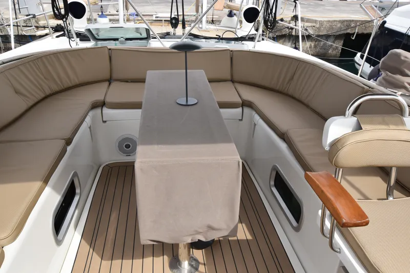 Artemis Yacht Photos Pics Luxurious 2004 Beneteau 57 yacht cockpit with cushioned seating and covered table.