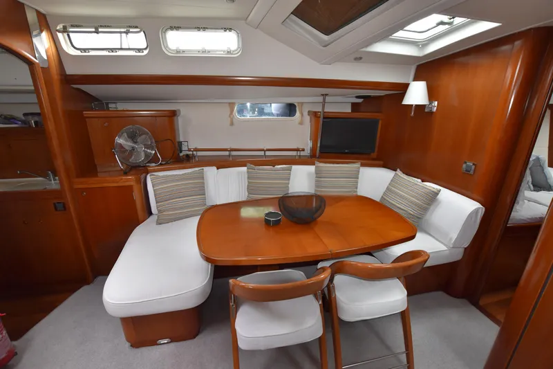 Artemis Yacht Photos Pics Luxurious interior of 2004 Beneteau 57 yacht with elegant dining area and plush seating.