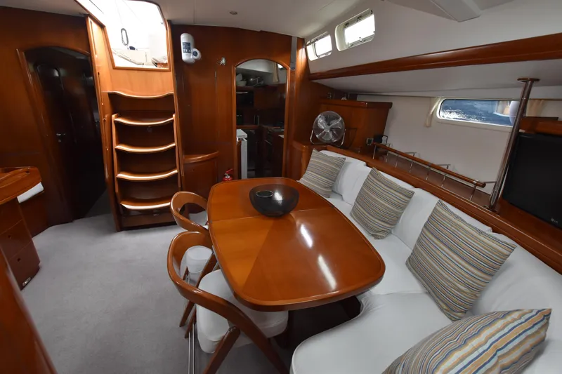 Artemis Yacht Photos Pics Luxurious interior of 2004 Beneteau 57 yacht with elegant wood finish and cozy seating area.