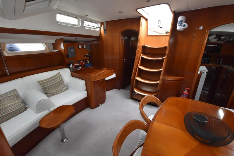 Artemis Yacht Photos Pics Luxurious interior of 2004 Beneteau 57 yacht with elegant wood finish and comfortable seating.