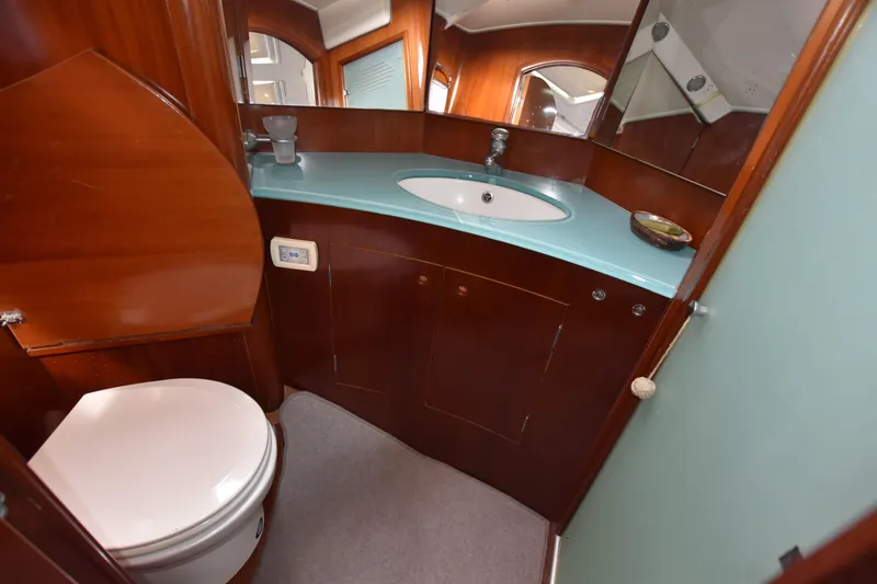 Artemis Yacht Photos Pics Luxurious bathroom in 2004 Beneteau 57 yacht with modern sink and wooden cabinetry.