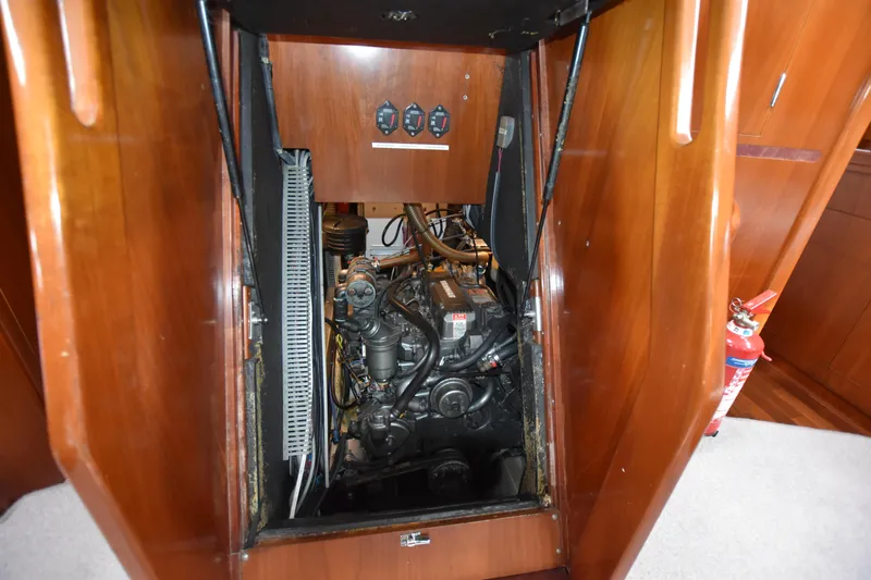 Artemis Yacht Photos Pics Engine compartment of a 2004 Beneteau 57 yacht, featuring wooden paneling and visible machinery.