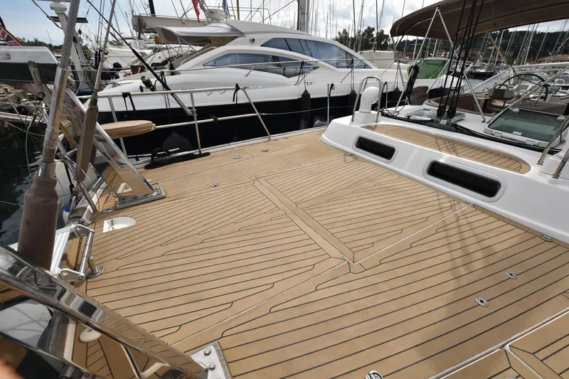 Artemis Yacht Photos Pics Deck of a 2004 Beneteau 57 yacht, featuring sleek wooden design in a marina setting.