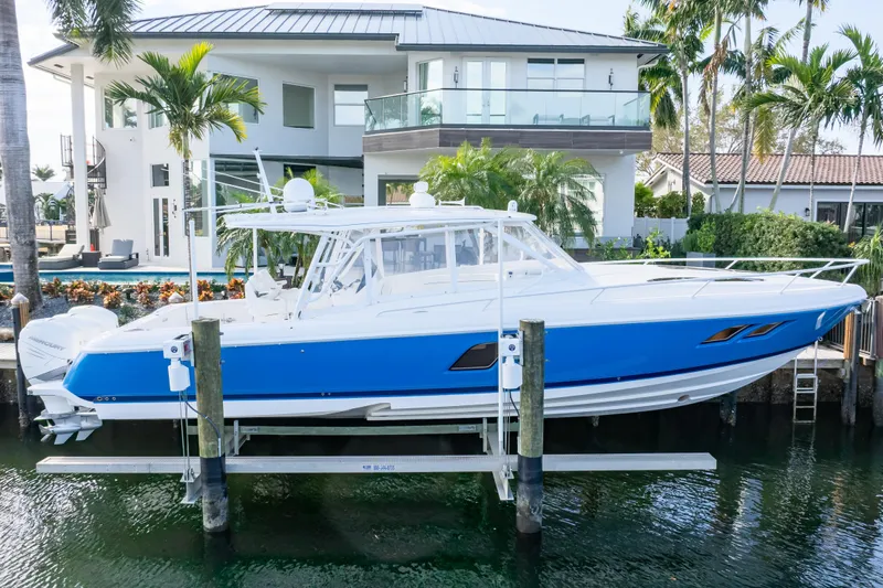  Yacht Photos Pics 2019 Intrepid 407 Cuddy boat docked near a modern waterfront home.