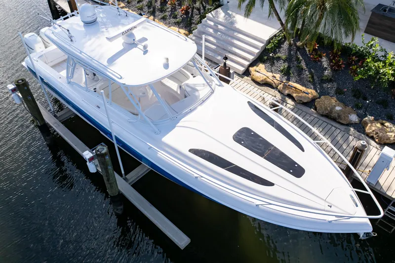  Yacht Photos Pics 2019 Intrepid 407 Cuddy boat docked by a tropical garden.