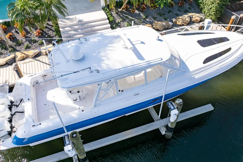  Yacht Photos Pics 2019 Intrepid 407 Cuddy boat docked, aerial view, surrounded by lush greenery.