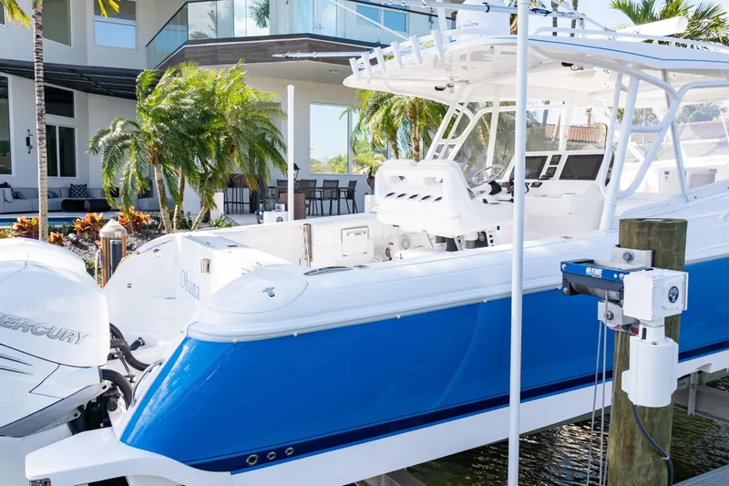  Yacht Photos Pics 2019 Intrepid 407 Cuddy boat docked near a modern waterfront home.