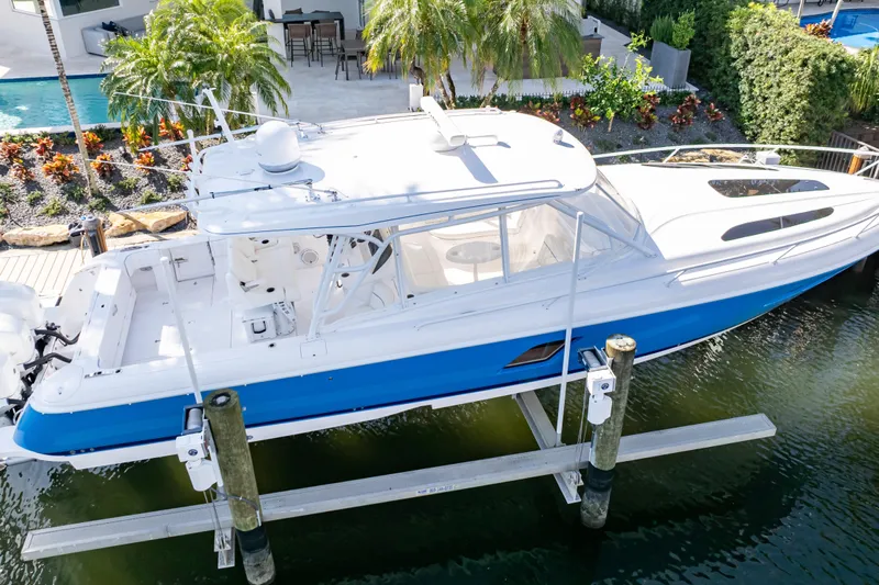  Yacht Photos Pics 2019 Intrepid 407 Cuddy boat docked, featuring sleek design and vibrant blue hull.
