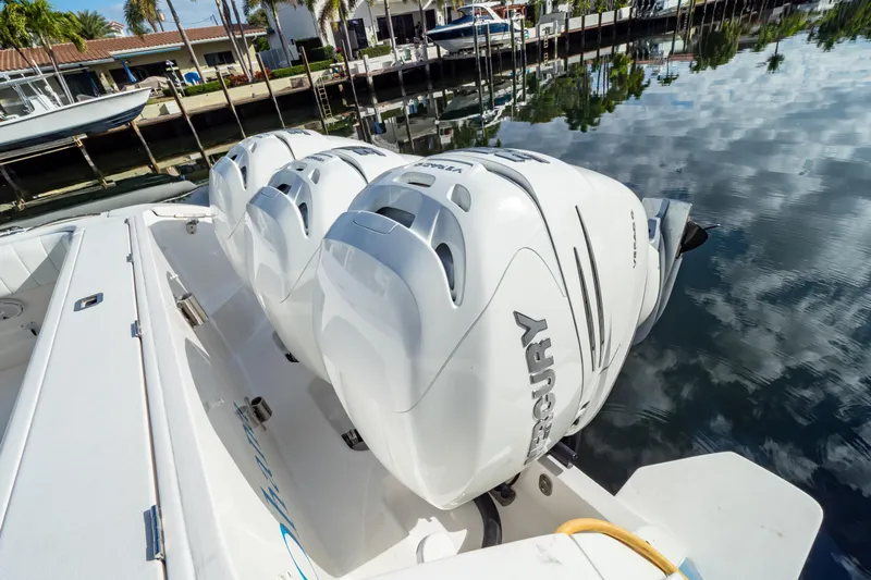  Yacht Photos Pics 2019 Intrepid 407 Cuddy with triple Mercury outboard engines docked by calm water.