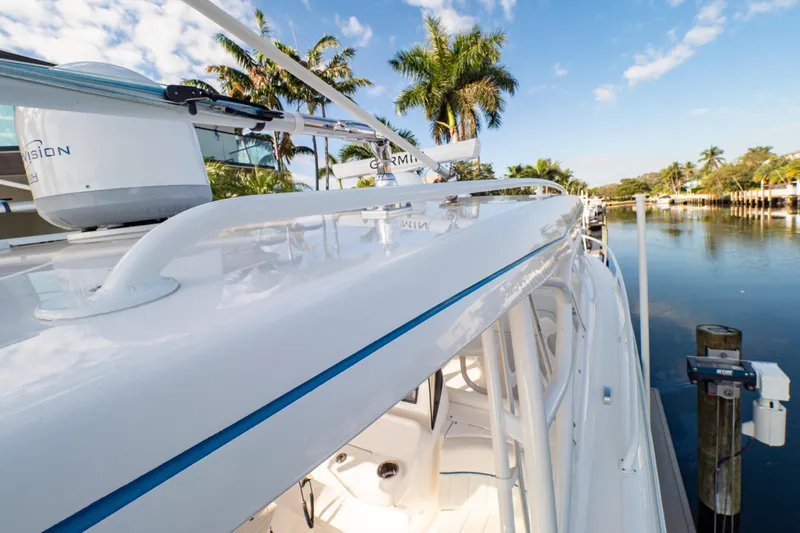  Yacht Photos Pics 2019 Intrepid 407 Cuddy boat docked by a serene waterfront with palm trees.