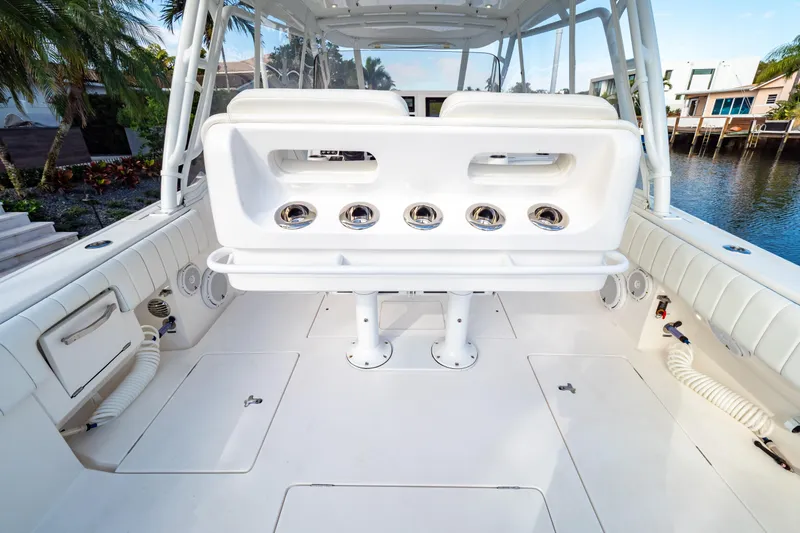  Yacht Photos Pics 2019 Intrepid 407 Cuddy boat interior with seating and rod holders, docked by waterfront homes.