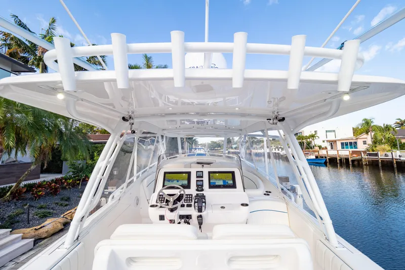  Yacht Photos Pics 2019 Intrepid 407 Cuddy boat interior with advanced navigation system, docked by a scenic waterfront.