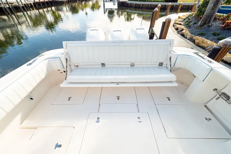  Yacht Photos Pics 2019 Intrepid 407 Cuddy boat with spacious seating and storage, docked by calm waters.