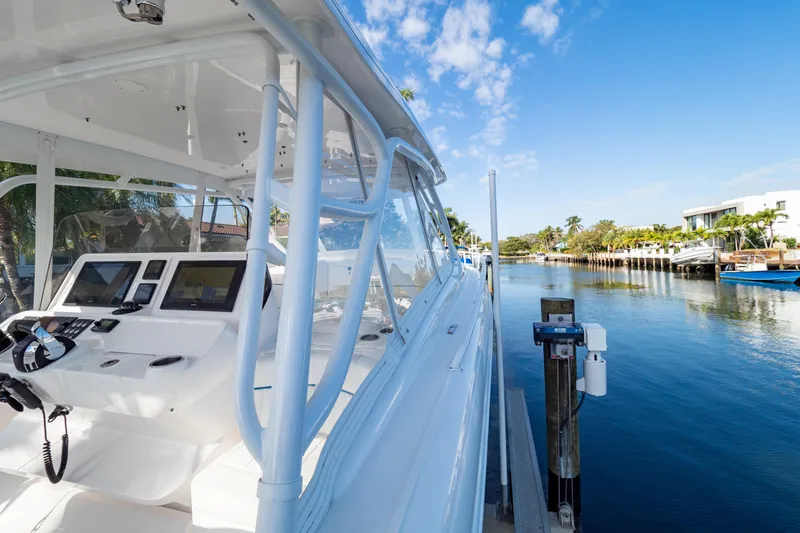  Yacht Photos Pics 2019 Intrepid 407 Cuddy boat docked by a scenic waterfront under a clear blue sky.
