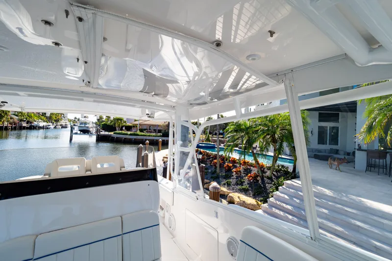  Yacht Photos Pics 2019 Intrepid 407 Cuddy boat docked by a scenic waterfront with lush greenery.
