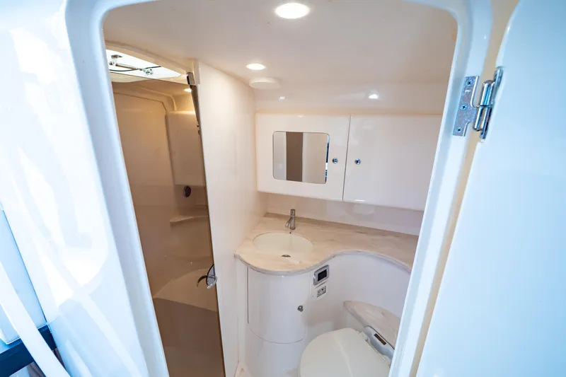  Yacht Photos Pics Luxurious bathroom interior of 2019 Intrepid 407 Cuddy boat, featuring modern fixtures and lighting.
