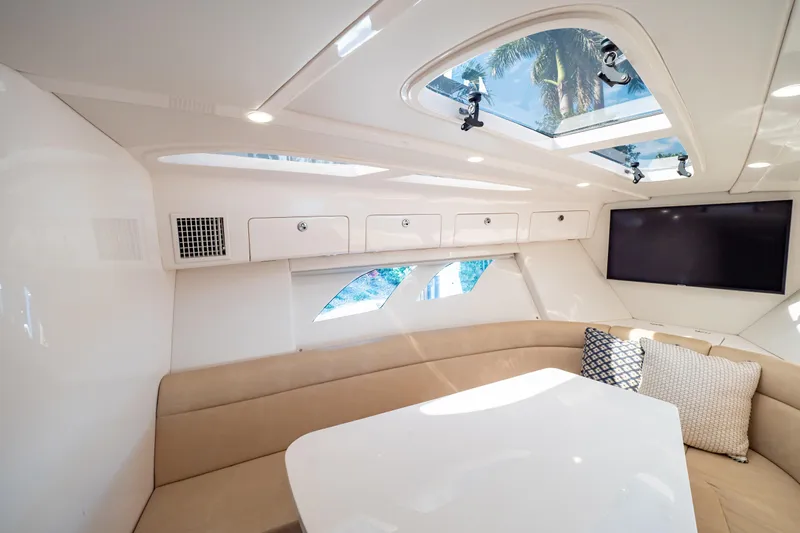  Yacht Photos Pics Luxurious interior of 2019 Intrepid 407 Cuddy with skylights, seating, and TV.