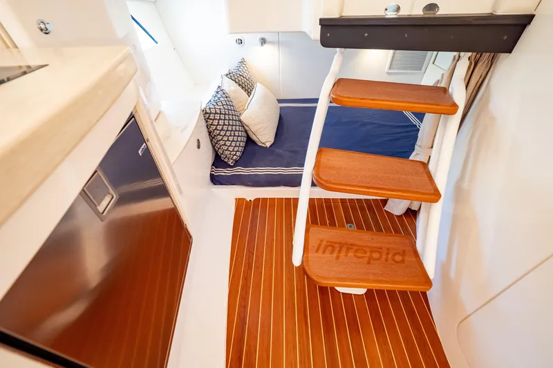  Yacht Photos Pics Interior of 2019 Intrepid 407 Cuddy with wooden steps and cozy bedding.