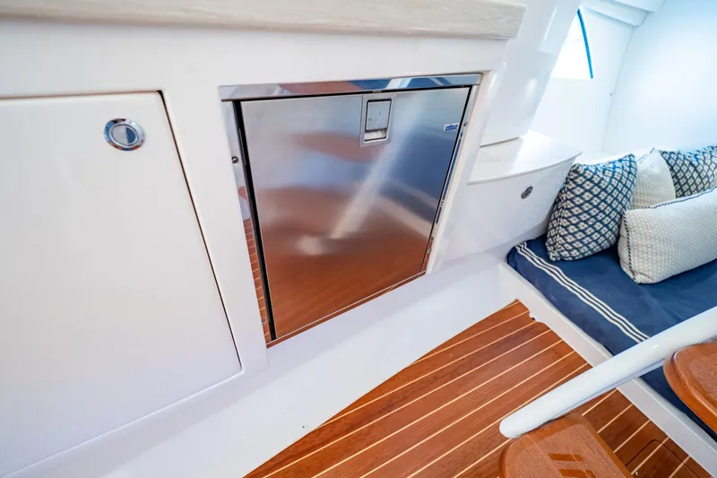  Yacht Photos Pics Interior of 2019 Intrepid 407 Cuddy with stainless steel fridge and cushioned seating.
