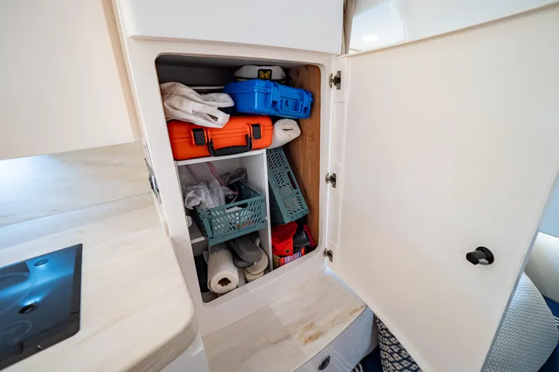  Yacht Photos Pics Storage cabinet on 2019 Intrepid 407 Cuddy boat, containing various supplies and equipment.