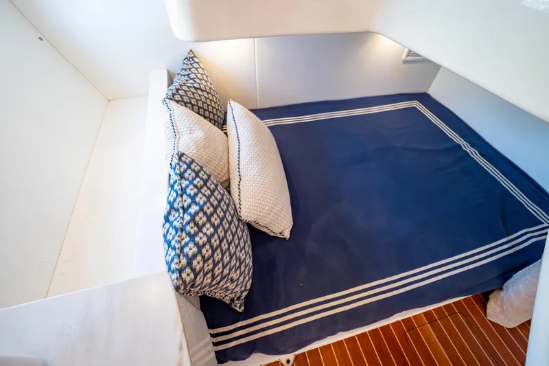  Yacht Photos Pics 2019 Intrepid 407 Cuddy cabin with blue bedding and patterned pillows.
