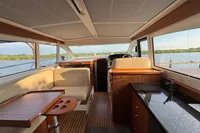 Interior of 2020 Nimbus 405 Coupé yacht with elegant wood finish and scenic water view.