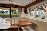 Interior of 2020 Nimbus 405 Coupé yacht with elegant seating and wooden table.
