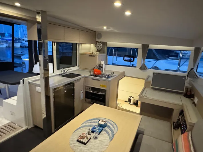 Encore Yacht Photos Pics Modern interior of 2021 Lagoon 40 catamaran with kitchen and dining area.