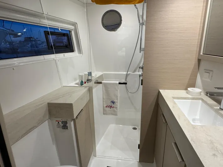 Encore Yacht Photos Pics Modern bathroom in 2021 Lagoon 40 yacht, featuring shower, sink, and window.