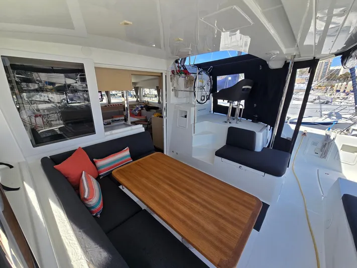 Encore Yacht Photos Pics Interior of 2021 Lagoon 40 catamaran with seating area and wooden table.