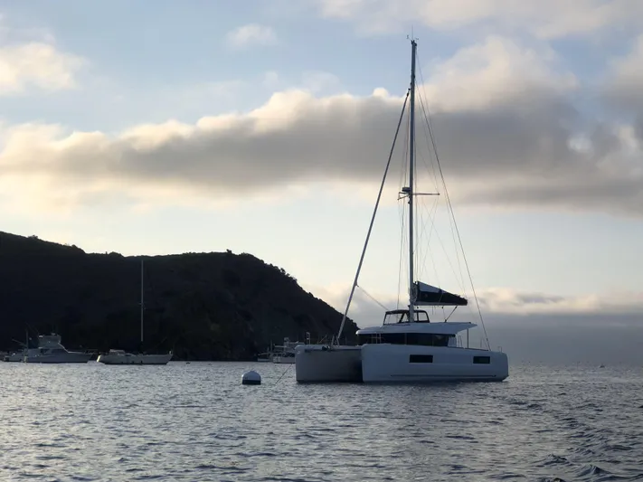 Encore Yacht Photos Pics 2021 Lagoon 40 catamaran anchored in serene waters at sunset.