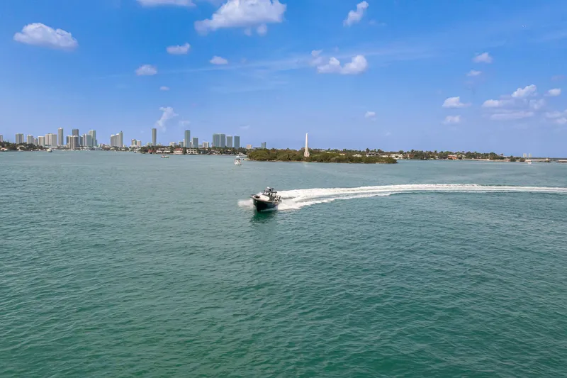  Yacht Photos Pics 2025 Buddy Davis PININFARINA 47 CC cruising on a sunny day near city skyline.