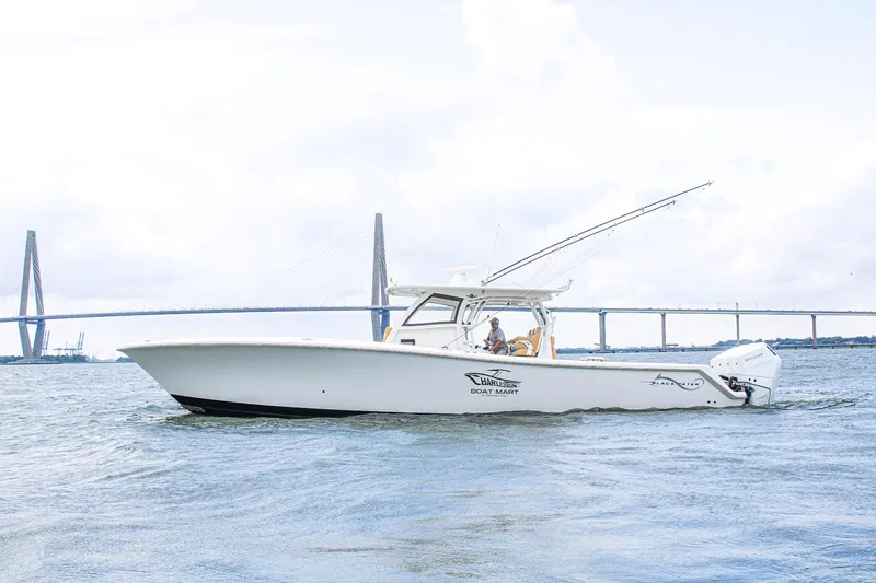  Yacht Photos Pics 2024 Blackwater 43 Sportfish boat cruising near a bridge on a cloudy day.