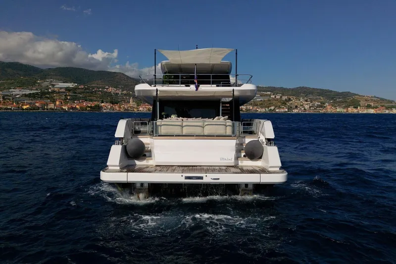  Yacht Photos Pics 2025 Ferretti Yachts INFYNITO 90 cruising on open sea with coastal backdrop.