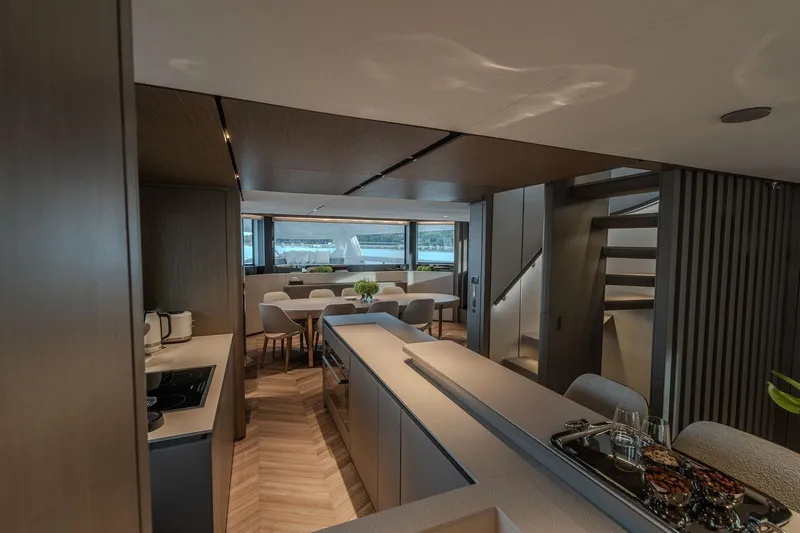  Yacht Photos Pics Luxurious interior of 2025 Ferretti Yachts INFYNITO 90, featuring modern dining and kitchen area.