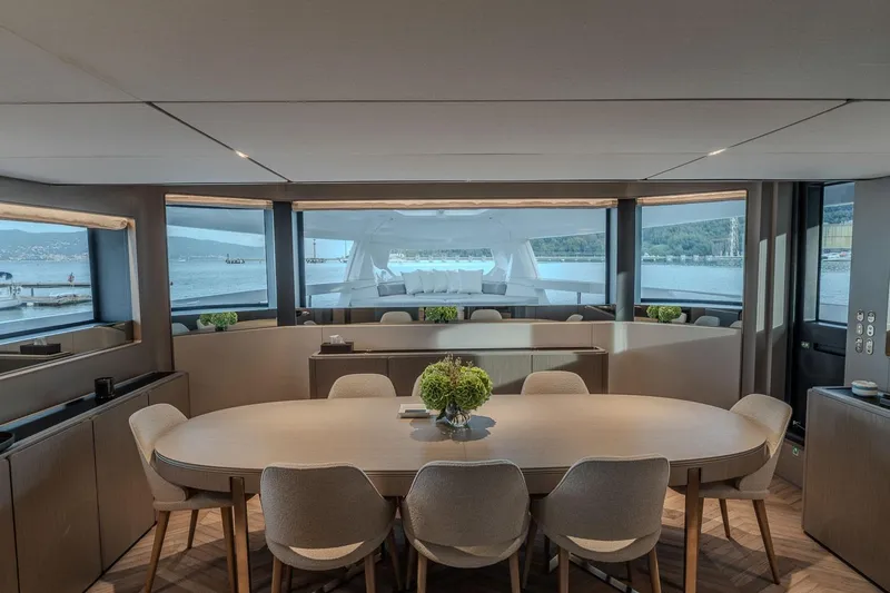  Yacht Photos Pics Luxurious interior of 2025 Ferretti Yachts INFYNITO 90, featuring elegant dining area with panoramic views.