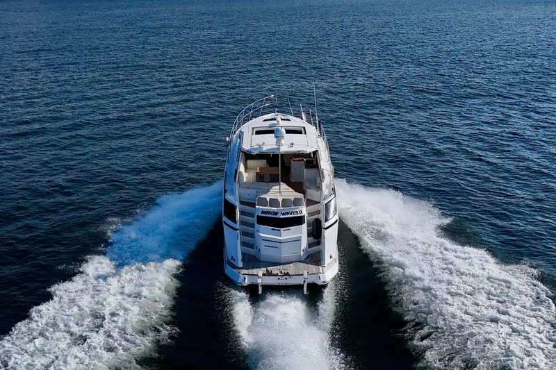 Makin' Waves II Yacht Photos Pics 2011 Regal 52 Sport Coupe cruising on open water, rear view.