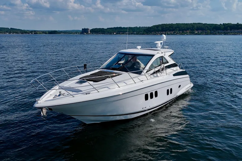 Makin' Waves II Yacht Photos Pics 2011 Regal 52 Sport Coupe yacht cruising on a calm lake under a partly cloudy sky.