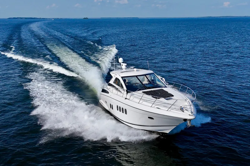 Makin' Waves II Yacht Photos Pics 2011 Regal 52 Sport Coupe cruising on open water, leaving a wake behind.