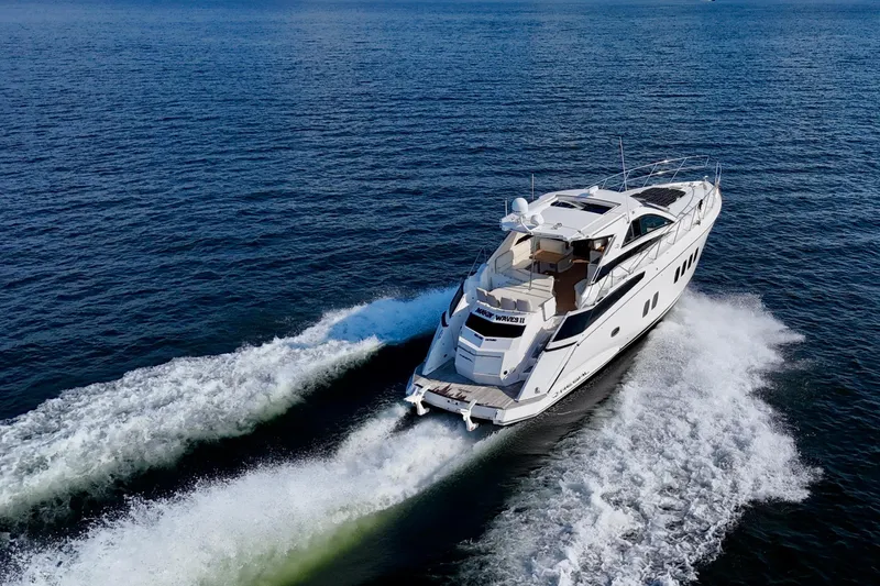 Makin' Waves II Yacht Photos Pics 2011 Regal 52 Sport Coupe yacht cruising on open water, leaving a wake.