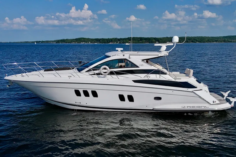 Makin' Waves II Yacht Photos Pics 2011 Regal 52 Sport Coupe yacht cruising on a serene lake under a clear blue sky.