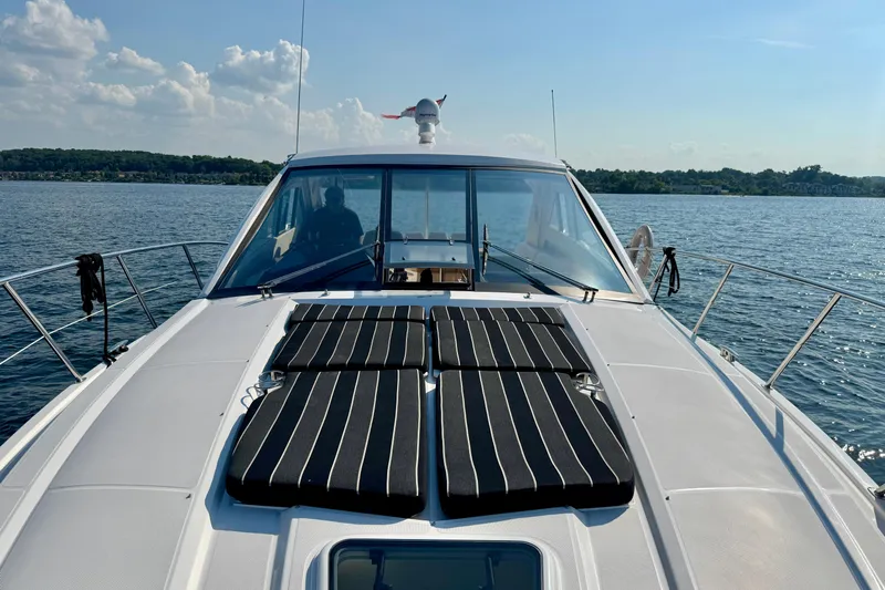 Makin' Waves II Yacht Photos Pics 2011 Regal 52 Sport Coupe yacht on calm water, featuring sunbathing pads and sleek design.