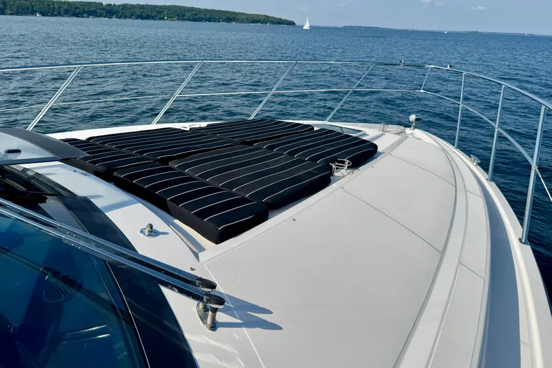 Makin' Waves II Yacht Photos Pics 2011 Regal 52 Sport Coupe yacht deck with sun pads on a serene lake.