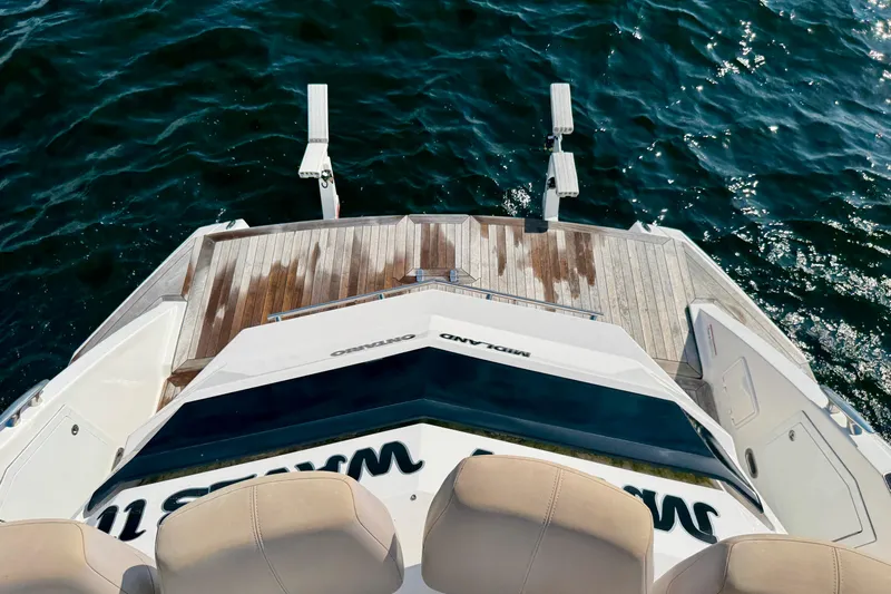 Makin' Waves II Yacht Photos Pics 2011 Regal 52 Sport Coupe yacht with wooden deck, overlooking ocean water.