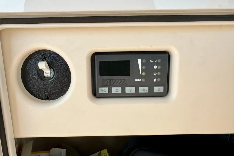 Makin' Waves II Yacht Photos Pics Control panel of a 2011 Regal 52 Sport Coupe, featuring switches and digital display.