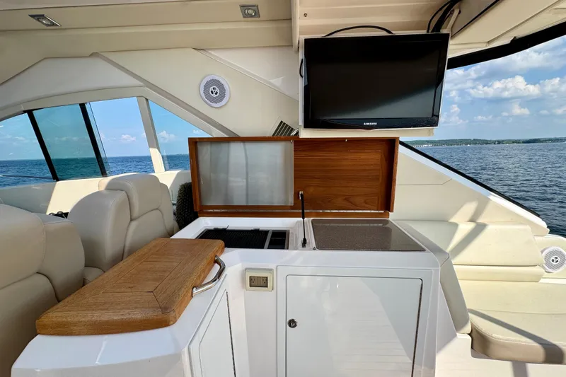 Makin' Waves II Yacht Photos Pics Luxurious interior of 2011 Regal 52 Sport Coupe yacht with TV and kitchenette.