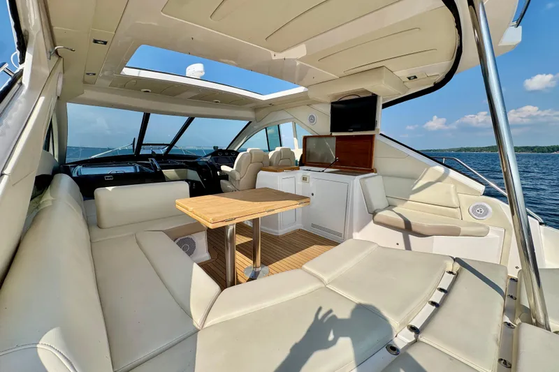 Makin' Waves II Yacht Photos Pics Luxurious interior of 2011 Regal 52 Sport Coupe yacht with leather seating and wooden table.